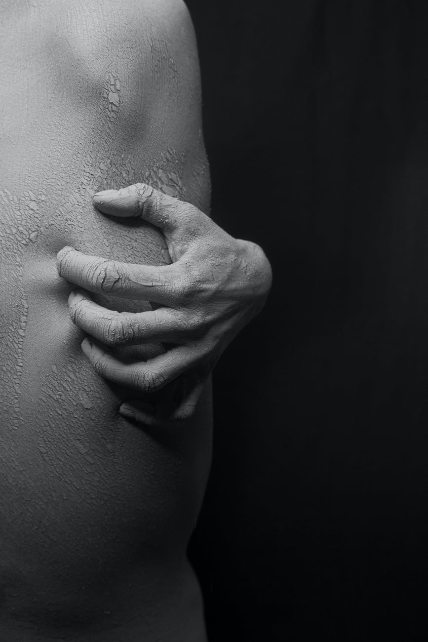 close up photo of a person s hand scratching on his flaky skin in black and white